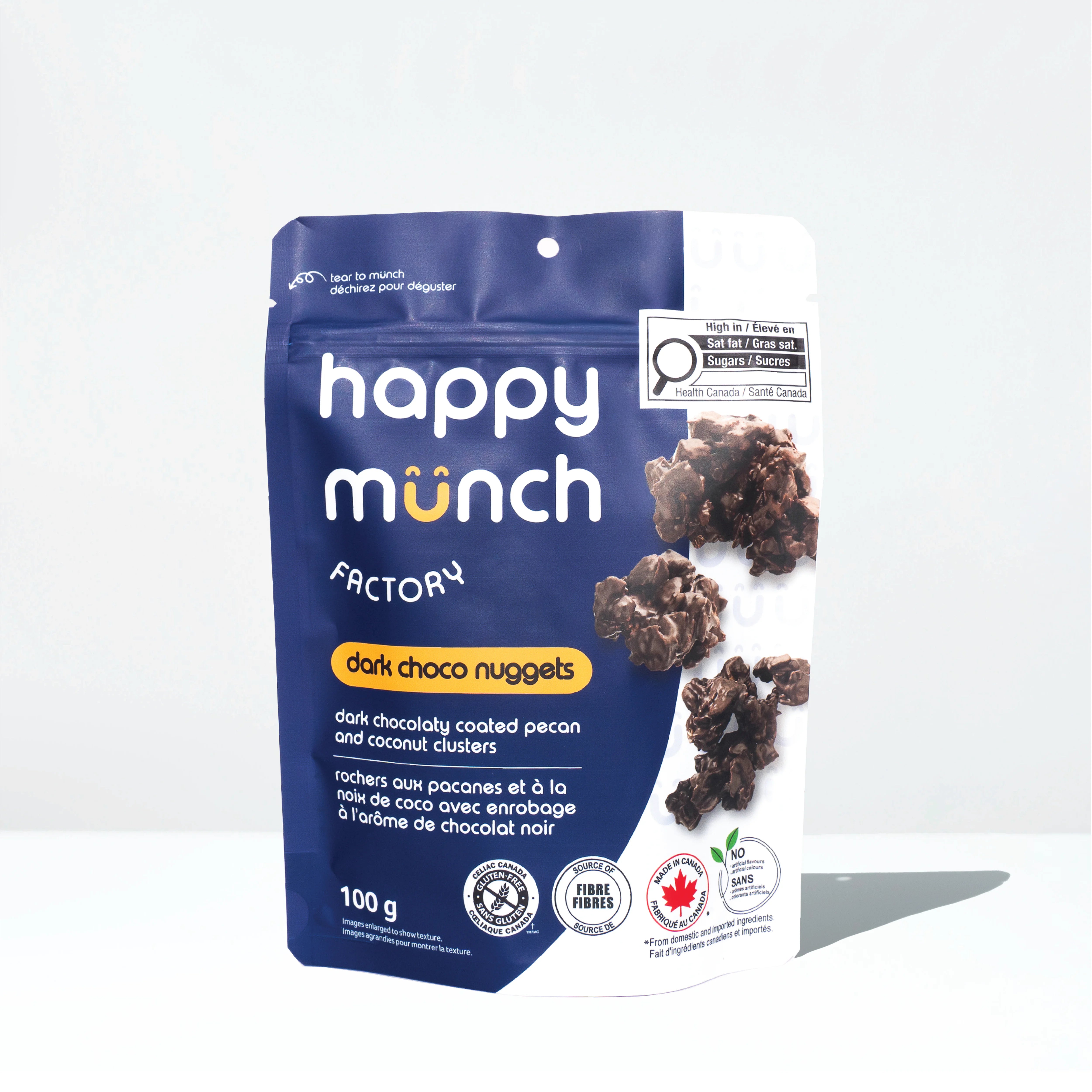 Front of Happy Munch Dark Choco Nuggets Chocolaty coated pecan and coconut clusters on a white background.